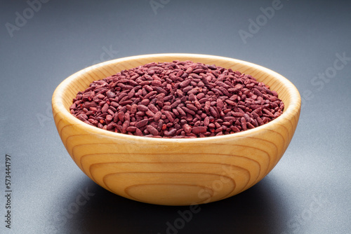 Red yeast rice in a wooden bowl. Chinese traditional food and medicine. photo