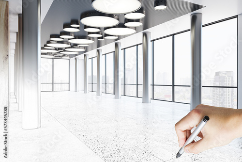 Handwritten modern business center interior design project with stylish lamps on top and city view background from big windows and human hand with pencil