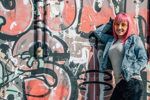 urban woman leaning on graffiti wall