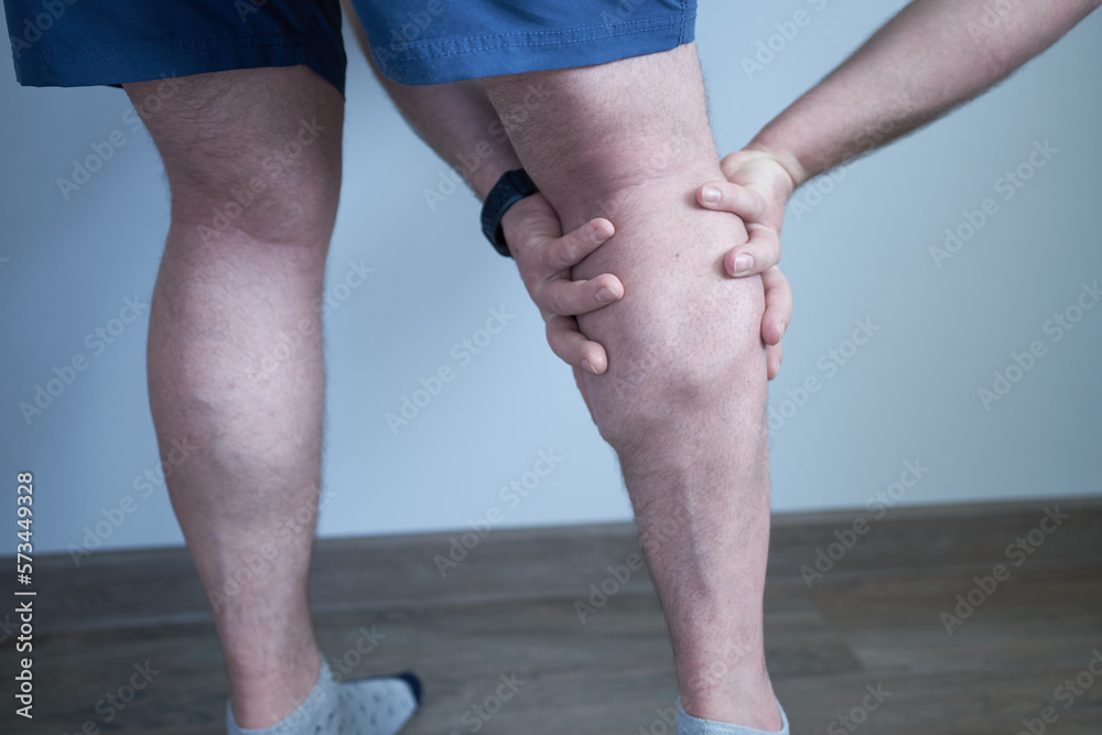 Pain in the muscles, a person touches the leg. Pain in the calves