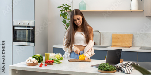An attractive blogger cuts a vegetable salad while broadcasting the process live. Healthy eating, vegetarianism.