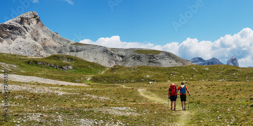 Couple hiking towards Rifugio Puez, Dolomites, Italy photo