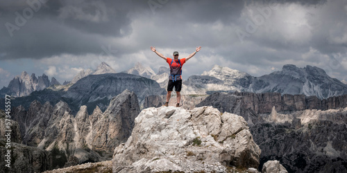 Carefree man standing with arms raised at Langkofel, Dolomites, Italy photo