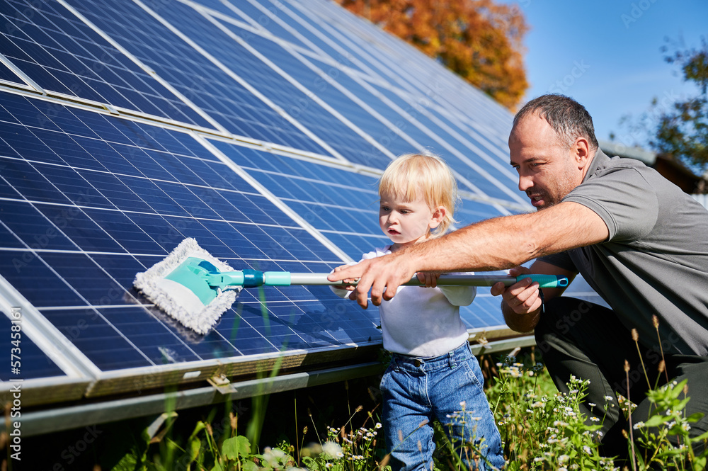Father showing his little son the solar panels during sunny day. Cute