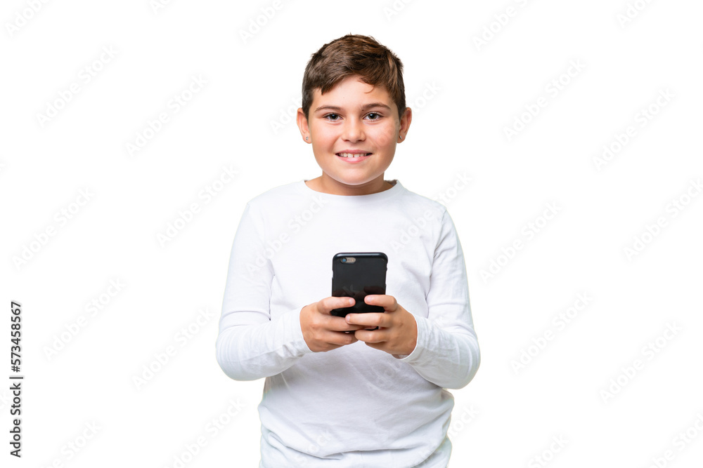 Little caucasian kid over isolated chroma key background sending a message with the mobile Little caucasian kid over isolated chroma key background sending a message with the mobile