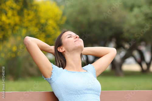 Relaxed teen on a bench in a park