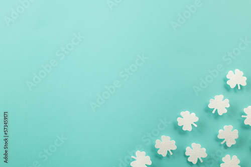 Happy St. Patrick's Day decoration background. Flat lay of cutting paper clover leaves festive decor, shamrocks leaves holiday symbol with copy space on colour background, Banner greeting card concept