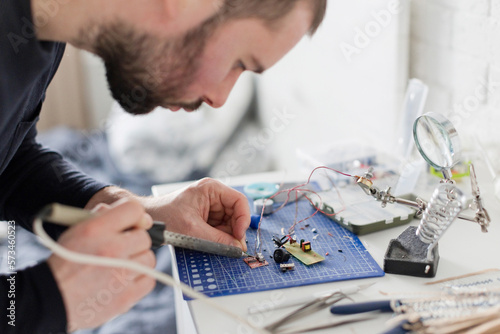 Engineer soldering circuit board at workshop photo