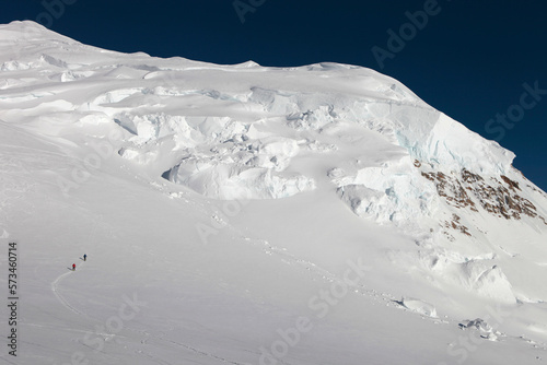 Two mountaineers are walking over the upper Kahiltna glacier at 12.000 feet on Mt. McKinley. Big seracs (ice masses) are in the background. photo