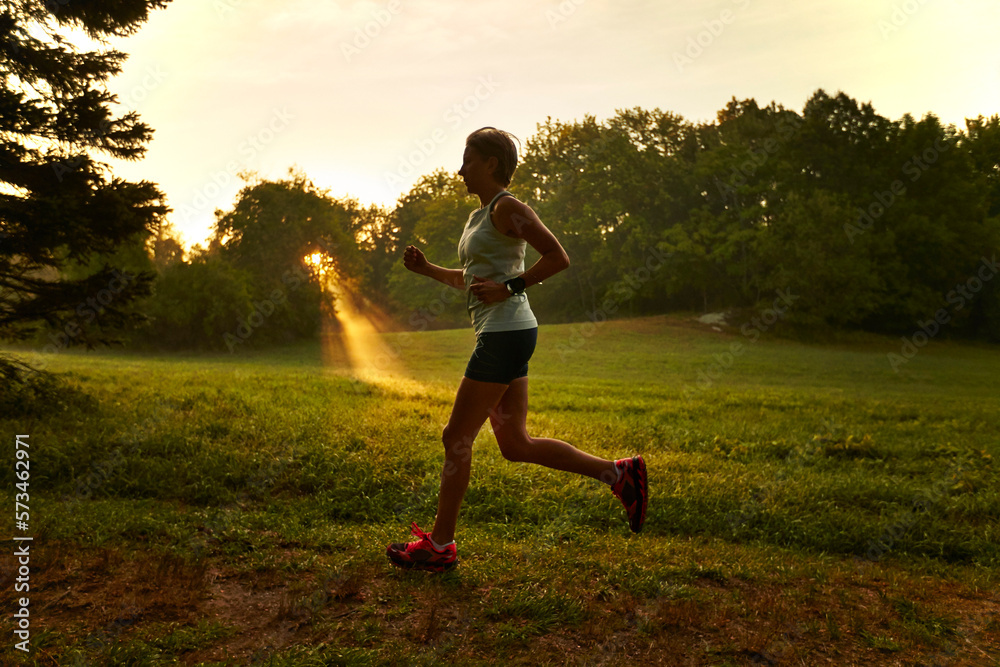 A woman running at sunrise. A woman running at sunrise.