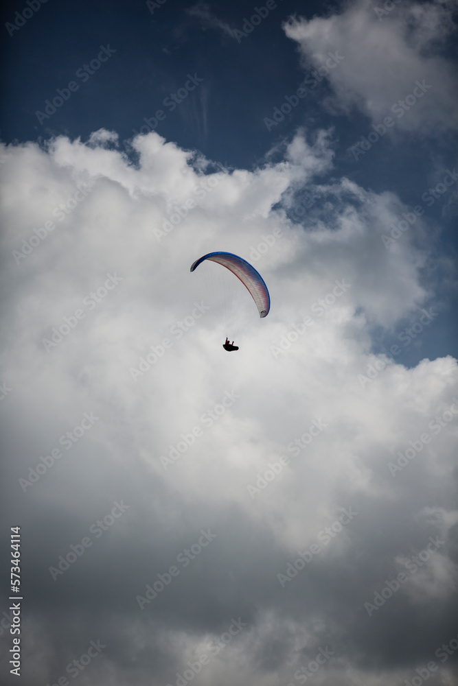 Paraglider in the sky in front of puffy clouds. Wasserkuppe, Rhoen Mountains, Germany Paraglider in the sky in front of puffy clouds. Wasserkuppe, Rhoen Mountains, Germany
