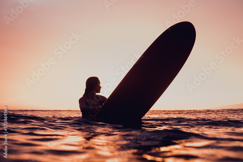 Pregnant female surfer holding surfboard, Las Americas, Tenerife, Spain photo