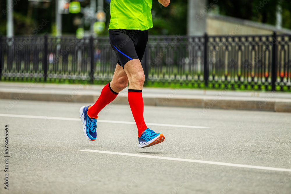 legs male runner in bright red compression socks run down street race legs male runner in bright red compression socks run down street race