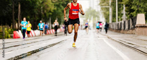 leader marathon race athlete runner run in rain on city street