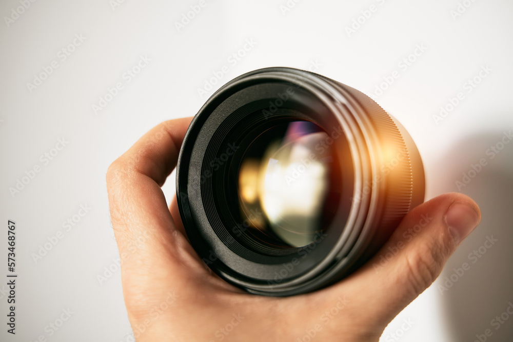 Banner of a photography lens in a hand. Modern photolens for digital mirrorless camera. Professional photogear Banner of a photography lens in a hand. Modern photolens for digital mirrorless camera. Professional photogear