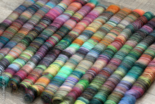 Closeup detail of handmade rolags of sheep wool and other fibres which were blended on a blending board ready for spinning on a  handspindle or a traditional spinning wheel. photo