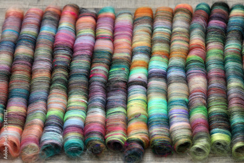 Closeup detail of handmade rolags of sheep wool and other fibres which were blended on a blending board ready for spinning on a  handspindle or a traditional spinning wheel. photo