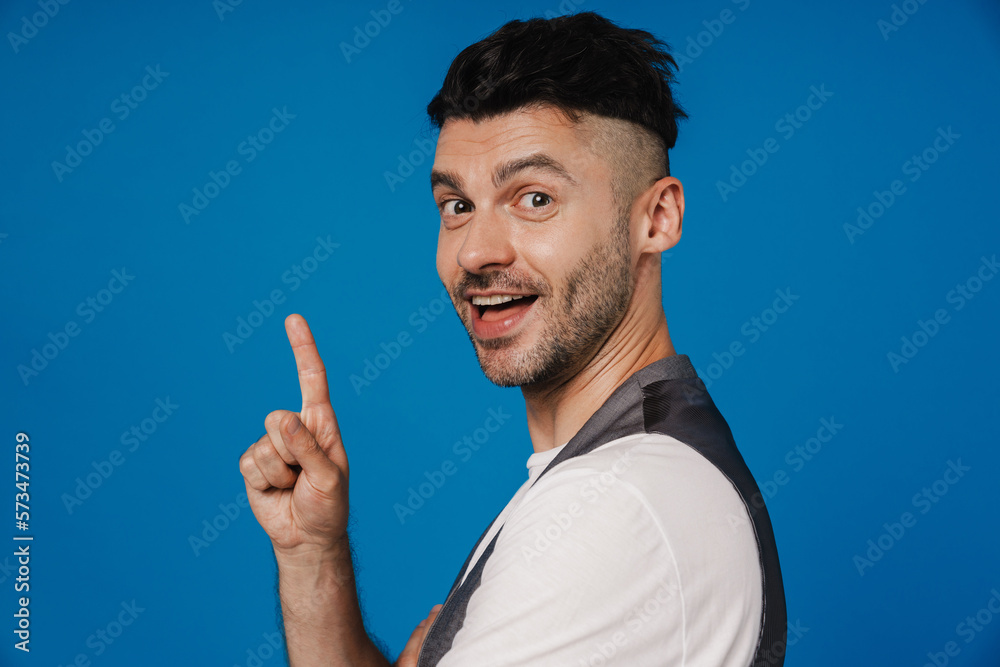 Young white unshaven man smiling and gesturing finger upwards Young white unshaven man smiling and gesturing finger upwards
