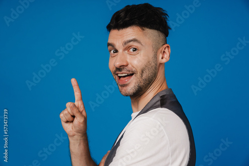 Young white unshaven man smiling and gesturing finger upwards