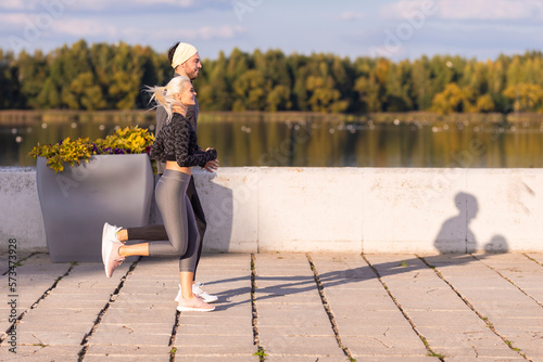 Jogging Training. Two Positive Caucasian Runners Athletes Training Together During Running Fitness Exercise At River Outside as Runners During Training Outdoor Process. photo