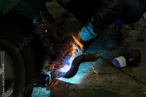  welder performs welding works of metal structures for custom cars