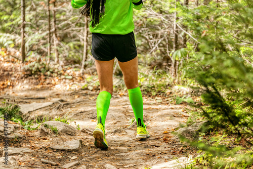 girl runner in compression socks run forest trail race