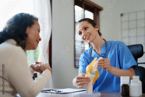 Portrait of a female doctor talking to an elderly patient about osteoarthritis.