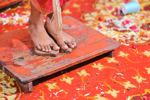 Wooden Slipper on the legs of boy in hindu ceremony pooja. Traditional Hindu Paduka. Upanayana Ceremony. Traditional Worship and Rituals for boys. Maharashtra culture.  photo