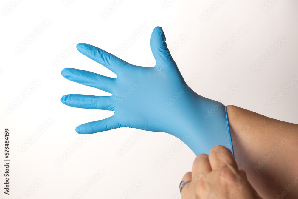 woman putting on blue latex gloves woman putting on blue latex gloves