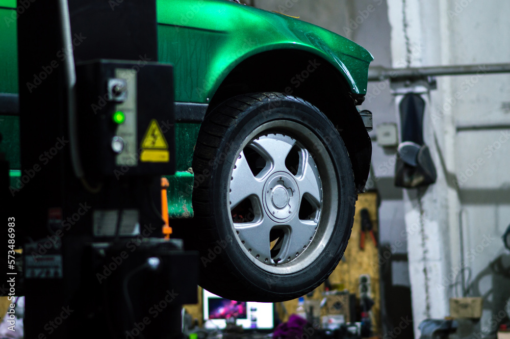 a mechanic disassembles an old dirty car engine on a red lift for repair and tuning turbo car