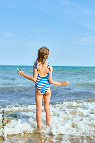 Happy, joyful little girl run on the beach