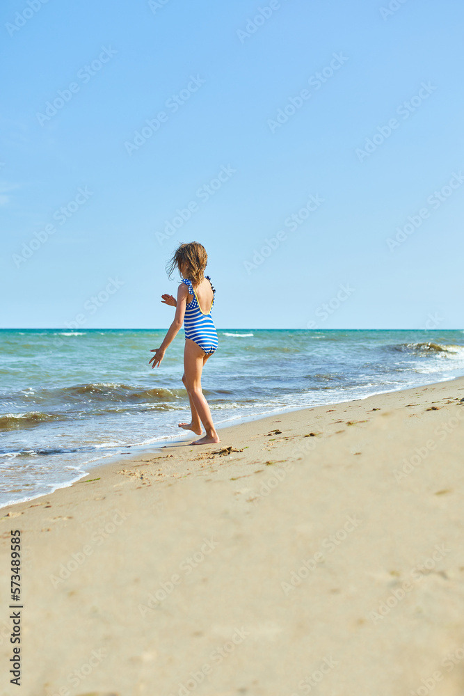 Happy, joyful little girl run on the beach