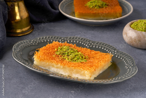 Middle eastern sweets kunefe, kunafa, kadayif with pistachio powder Turkish , arabic traditional dessert.