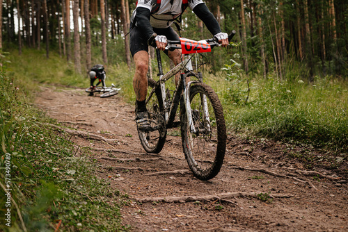 Tela athlete cyclist riding forest trail on mountain bike in cycling competition