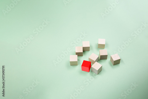 Wooden cubes randomly scattered on a green background. Copy space .