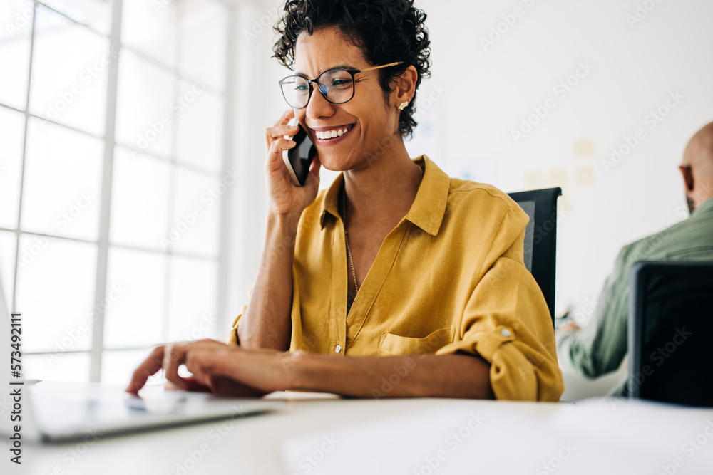 Female accountant talking on a phone call in an accounting firm - obrazy, fototapety, plakaty 