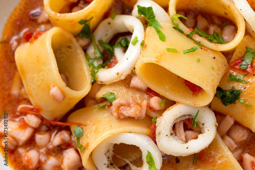 Calamarata, tradizionale piatto di pasta condita con sugo di calamari, cibo italiano 