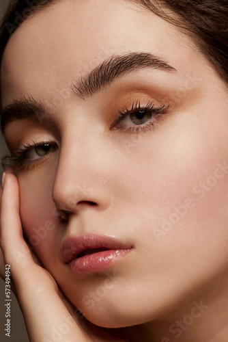 Purity and tenderness. Close-up portrait of young beautiful girl with shimmer eye shadow makeup. Well-kept healthy skin condition. Concept of natural beauty, skincare, cosmetology, cosmetics, health