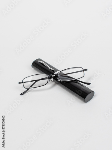 Beautiful black-rimmed reading glasses with a case isolated on white background. Studio shot