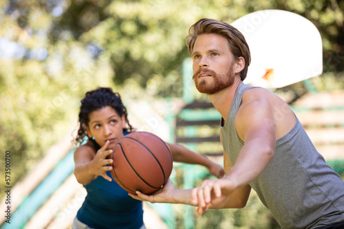 man and woman playing a mixed basketball game
