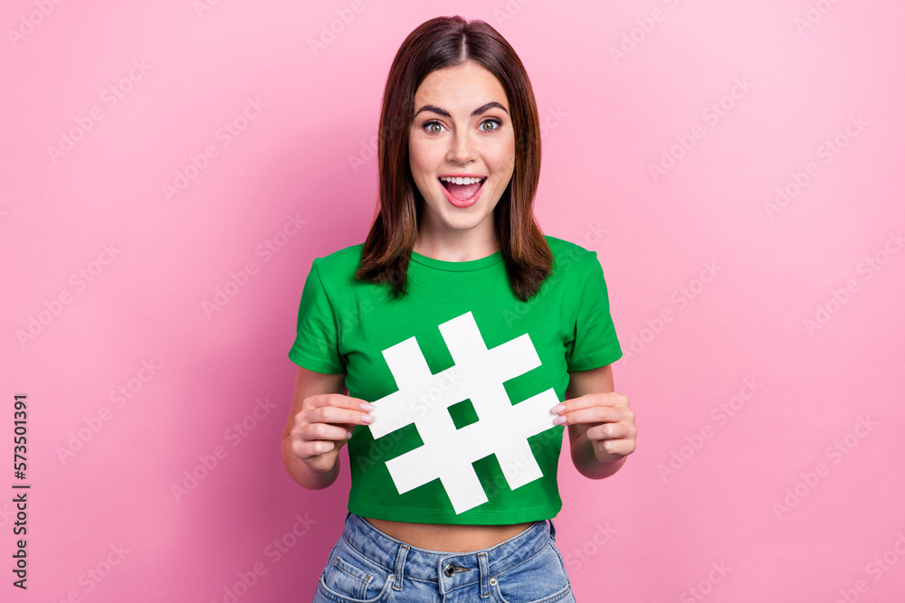 Portrait of lovely astonished lady open mouth hands hold paper hashtag symbol isolated on pink color background Portrait of lovely astonished lady open mouth hands hold paper hashtag symbol isolated on pink color background