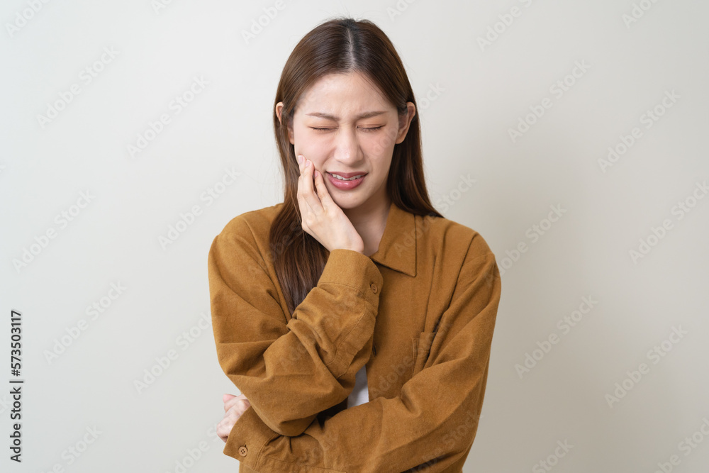 Woman touching her cheek and feeling hurt from toothache Woman touching her cheek and feeling hurt from toothache