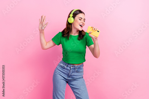 Portrait of cheerful pretty lady hold smart phone sing record voice isolated on pink color background