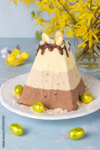 Traditional Easter curd dessert made of three types of chocolate - white, milk and black, decorated with chocolate eggs