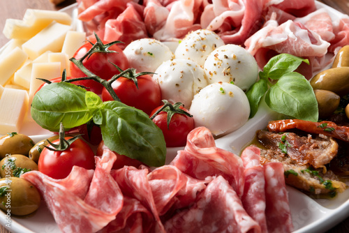 Vassoio con prodotti tipici Italiani, prosciutto crudo, salame, verdure, pecorino e mozzarella di bufala campana 
