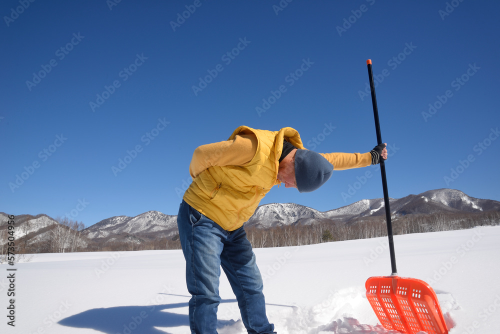雪国で除雪をして疲労している日本人シニア男性 雪国で除雪をして疲労している日本人シニア男性