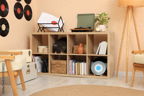 Vinyl record player on wooden shelving unit indoors photo