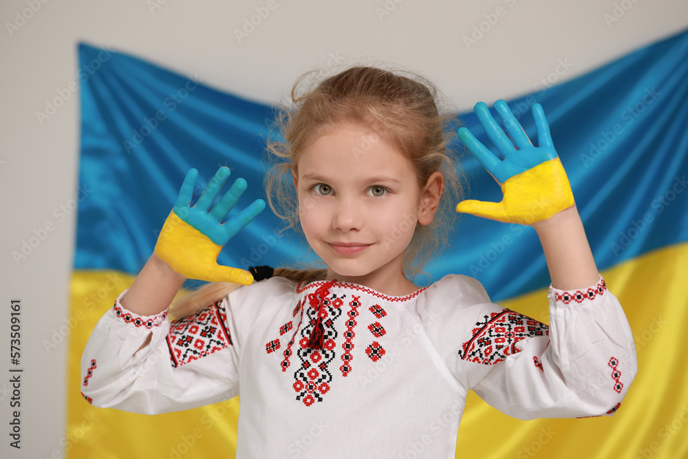 Little girl with painted hands near Ukrainian flag. Love Ukraine concept Little girl with painted hands near Ukrainian flag. Love Ukraine concept
