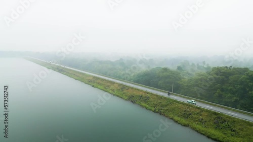 Tracking shot of a car as it travels alongside Loggal Oya reservoir in Sri Lanka photo