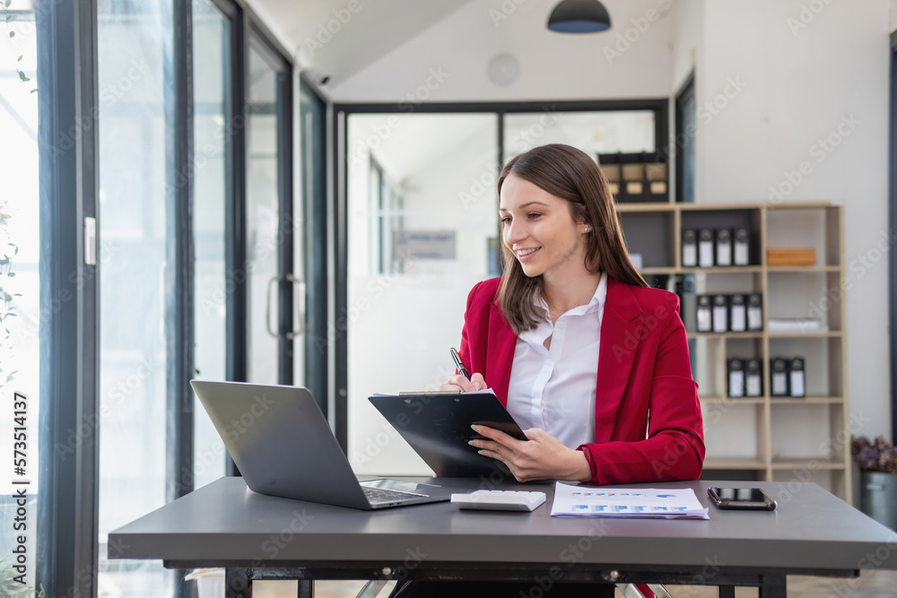 Marketing, Finance, Accounting, Planning, Team female accountant using laptop calculator and documents, charts, graphs in the analysis of the company is profit. Marketing, Finance, Accounting, Planning, Team female accountant using laptop calculator and documents, charts, graphs in the analysis of the company is profit.